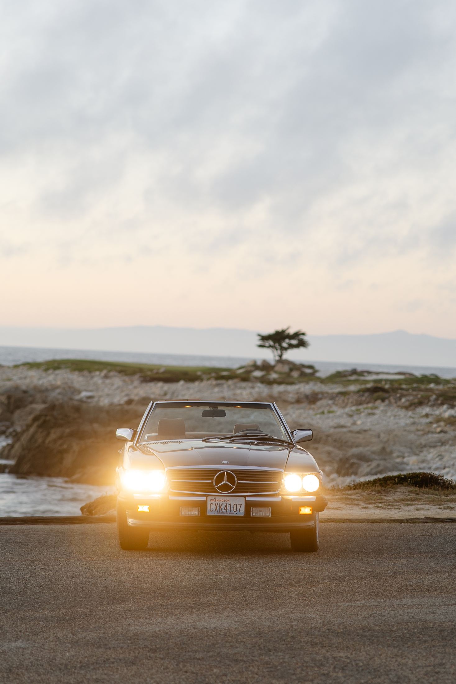 1988 Mercedes-Benz 560 at dusk with its headlights on